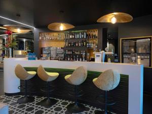 a bar with four stools in front of a counter at Mercure Orléans Centre Bords de Loire in Orléans
