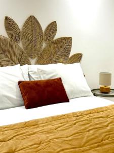 a bed with white pillows and a brown pillow on it at Casa da Vila Messines in São Bartolomeu de Messines