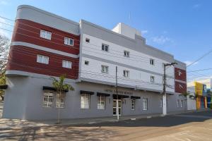 a building with a red and white facade on a street at Hotel Castro Mendes in Campinas
