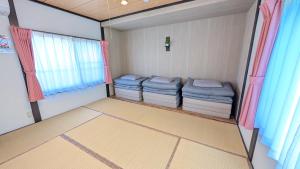 a small room with three mattresses and a window at 名鉄名古屋まで7分1棟貸し切り駐車場あり in Nishi-biwashima