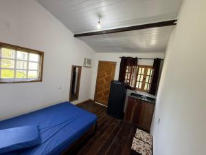 a bedroom with a blue bed and a door at Kit net great price in São Sebastião