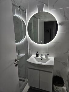 a white bathroom with a sink and a mirror at Miss LUX in Mladenovac +10 photos