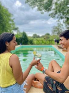 two women sitting next to a pool holding a drink at Che Cambá in Colonia Carlos Pellegrini +31 photos