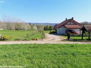 a house with a car parked next to a field at Charmant Gîte 4* dans un Hameau Paisible des Vosges - FR-1-583-388 in Fougerolles