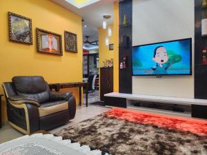 a living room with a tv and a reclining chair at HOMESTAY RIZQI - MUS LIM Only in Air Molek +6 photos