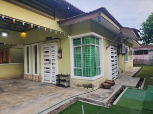 a small house with a patio and a yard at HOMESTAY RIZQI - MUS LIM Only in Air Molek
