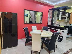 a dining room with a white table and black chairs at HOMESTAY RIZQI - MUS LIM Only in Air Molek
