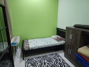 a small bedroom with a bed and a dresser at HOMESTAY RIZQI - MUS LIM Only in Air Molek