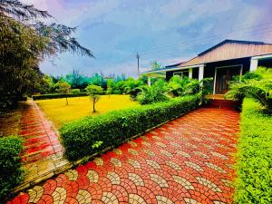 a house with a brick walkway in front of a yard at Elure Stays in Pātalpāni
