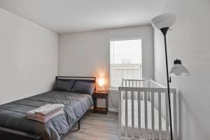 a bedroom with a bed and a crib and a window at Modern and Cozy Home in HTX in Houston
