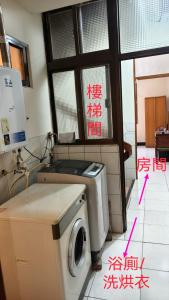 a washing machine in a room with writing on the floor at 豐陽客棧 in Fengyuan