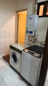 a kitchen with a washing machine and a microwave at 豐陽客棧 in Fengyuan