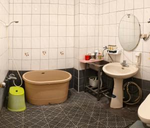 a bathroom with a tub next to a sink and a toilet at 豐陽客棧 in Fengyuan