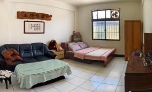 a living room with a couch and a bed at 豐陽客棧 in Fengyuan