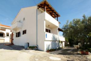 a white building with a wooden roof at Double Room Barbat 4862a in Barbat na Rabu