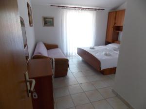 a hotel room with a bed and a couch at Double Room Barbat 4862a in Barbat na Rabu