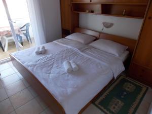 a bedroom with a bed with two slippers on it at Double Room Barbat 4862a in Barbat na Rabu +12 photos