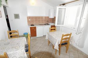 a kitchen with a table and a table and chairs at Double Room Barbat 4862a in Barbat na Rabu