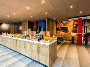 a restaurant with a counter with fruit on it at IBIS La Rochelle Vieux Port Centre in La Rochelle +38 photos