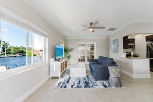 ein Wohnzimmer mit einer blauen Couch und einem großen Fenster in der Unterkunft Waterfront Intercoastal, Walk to the Beach, Pool & Hot Tub, Watch the Boats in Boca Raton