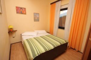 a small bedroom with a bed with a window at Apartment Pomer 7374a in Pomer