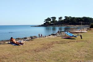 a group of people on a beach near the water at Apartment Pomer 7374a in Pomer