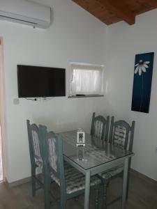 a dining room table with chairs and a television on the wall at Apartment Pomer 7374b in Pomer