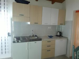 a kitchen with white cabinets and a sink at Apartment Pomer 7374b in Pomer +13 photos
