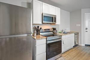 a kitchen with white cabinets and a stainless steel refrigerator at Modern Home with Spacious Yard in Houston in Houston
