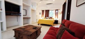 a living room with a red couch and a table at MINI PINI BIRD WATCHING AND CENOTE Loft in Cozumel