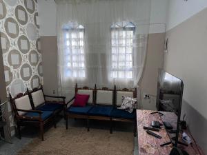ein Wohnzimmer mit zwei Stühlen und einem Tisch in der Unterkunft Casa Nhá Chica - Aparecida - a 10 minutos a pé do Santuário Nacional in Aparecida