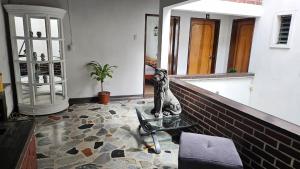 Una sala de estar con una estatua de un perro sobre una mesa. en Hotel Americano Plus, en Pereira