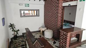 sala de estar con silla y pared de ladrillo en Hotel Americano Plus, en Pereira