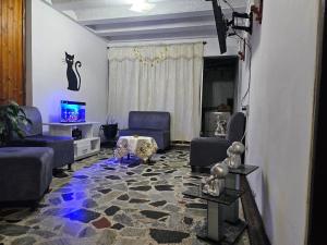 a living room with blue couches and a tv at Hotel Americano Plus in Pereira