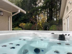 a jacuzzi tub with a view of a yard at Five Gables B&B in Qualicum Beach