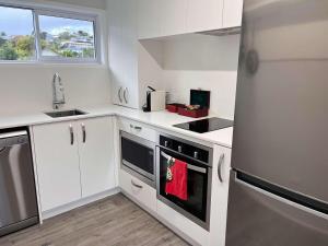 una cocina con armarios blancos y una toalla roja en el horno en The Pool House -New Listing Promo, en Russell