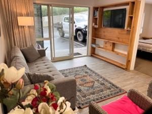 Una sala de estar con un sofá y un televisor. en The Pool House -New Listing Promo, en Russell