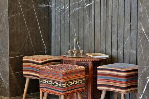 迪拜Hotel Local Dubai, Jumeirah Village Triangle, Autograph Collection的一张桌子和两张带桌椅的凳子