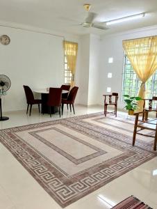 a room with a table and chairs and a rug at nearby umt unisza hosza litar gong badak airport chelong homestay kuala terengganu in Kampong Bukit Berangan