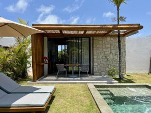 Un patio con una mesa y una piscina. en Umbelina Pousada Boutique, en Porto de Galinhas