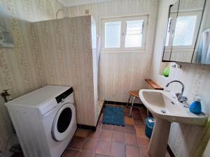 a bathroom with a washing machine and a sink at Holiday Home in Plozévet near Beaches in Plozévet