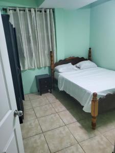 MahautにあるAshmak apartmentのタイルフロアのベッドルーム1室(ベッド1台付) +3枚の写真