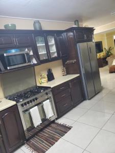 MahautにあるAshmak apartmentのキッチン(黒いキャビネット、ステンレス製の冷蔵庫付)