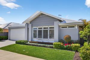 a house with a garage in a yard at Coastal Luxe 4-Bed House in Madora Bay in Singleton