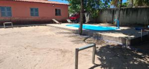 a swimming pool in a yard next to a house at Recanto Silvia Timbó in Aquiraz