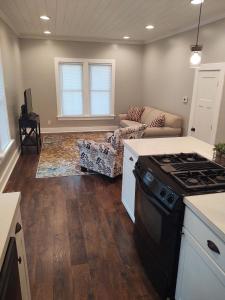 a kitchen with a stove and a living room at City Getaway in Midland
