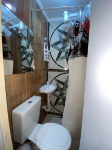 une salle de bains avec toilettes et lavabo dans l'établissement Pousada e Restaurante Toca do Camarão Gourmet, à Maricá