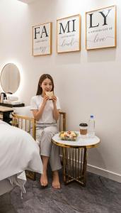 a woman sitting in a chair next to a table at InstaHotel-MainBranch in Suwon