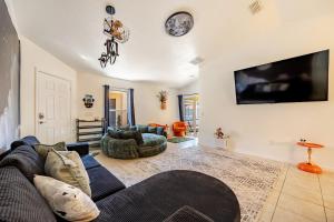 a living room with a couch and a tv on a wall at Magical World in Davenport