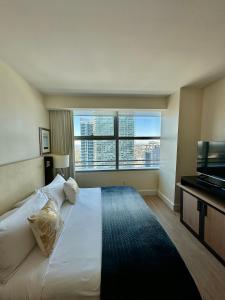 Un dormitorio con una gran cama blanca con una gran ventana. en Brickell 32th Floor AKA by Palermo Home Miami, en Miami